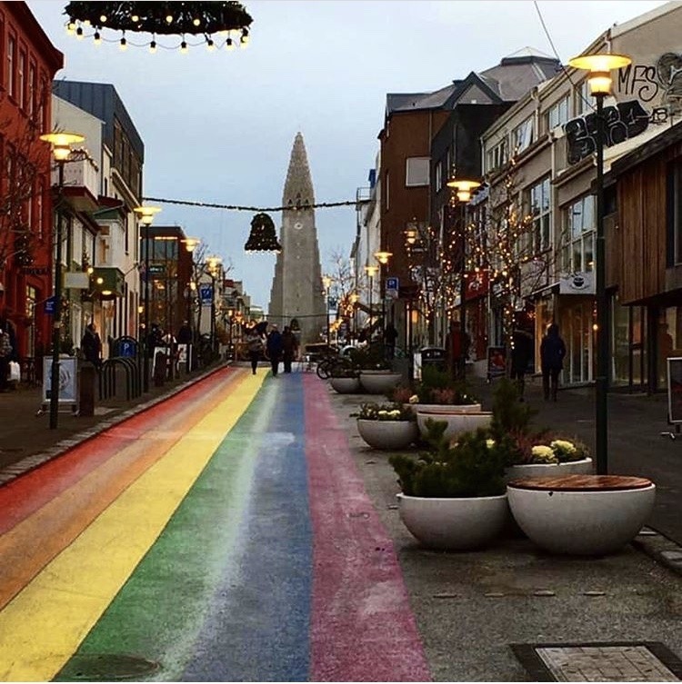 Street in Iceland with a church and rainbow painted on the pavement