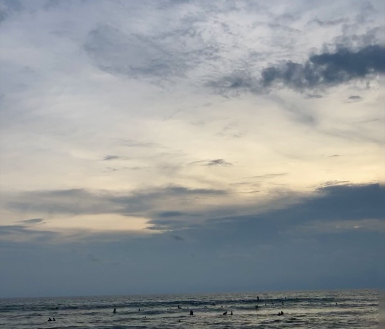 sunset with surfers in the sea