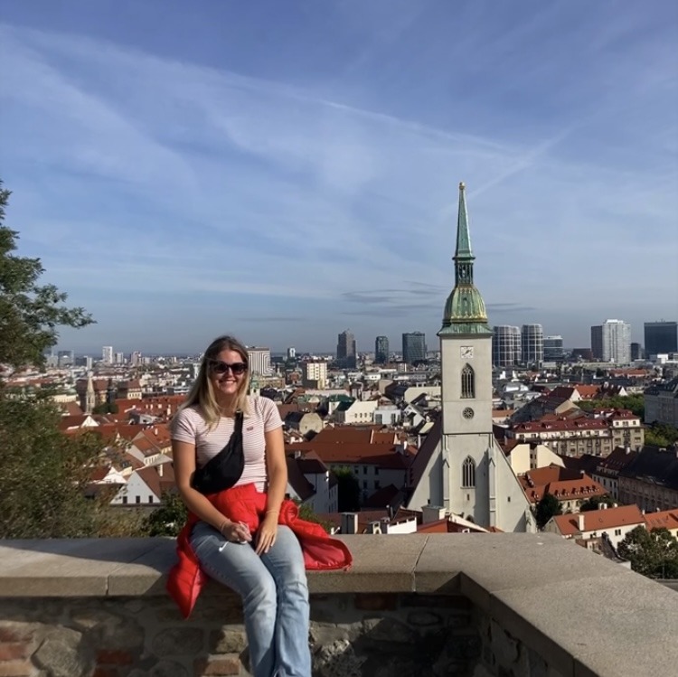 girl sitting on ledge with church in background