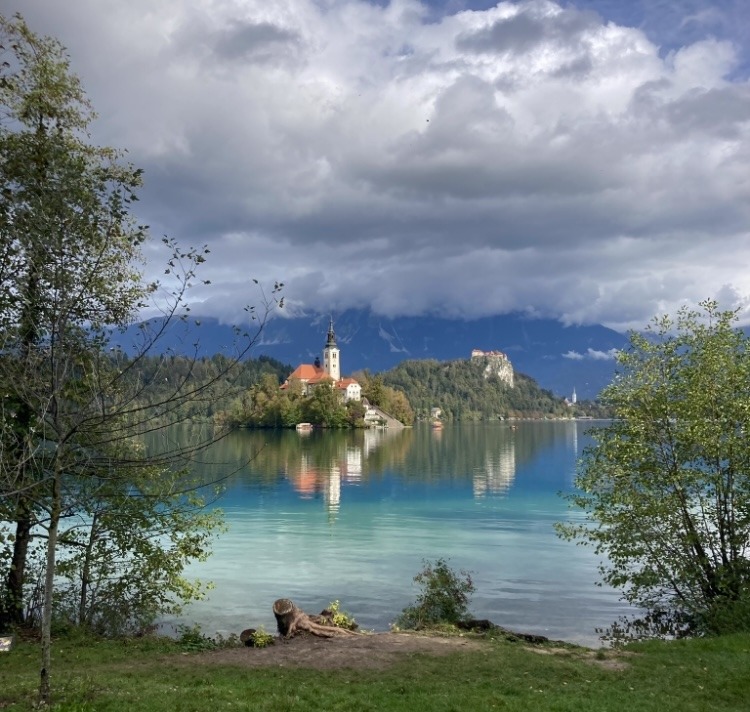 turquoise lake with island that has church on in background