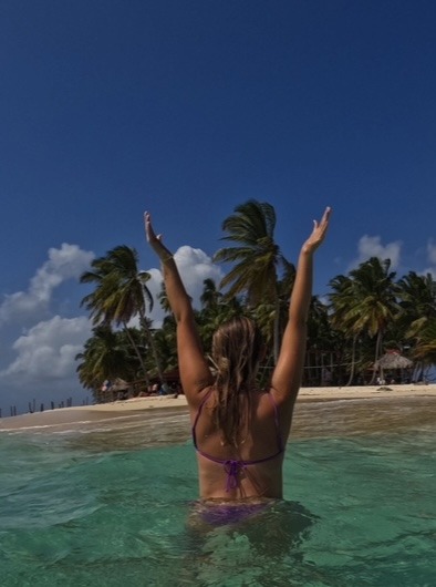 girl standing in water in front of island