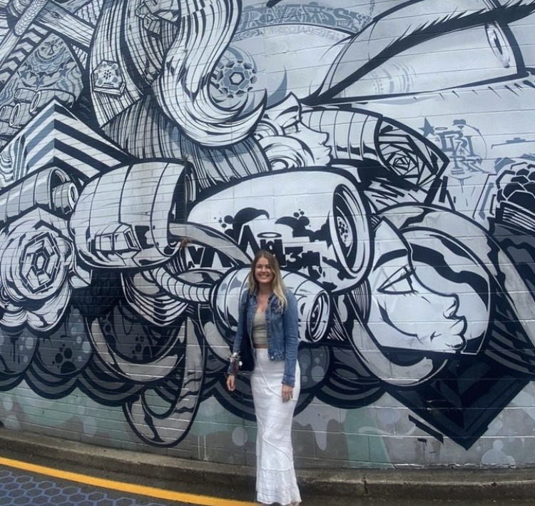 girl standing in front of street art