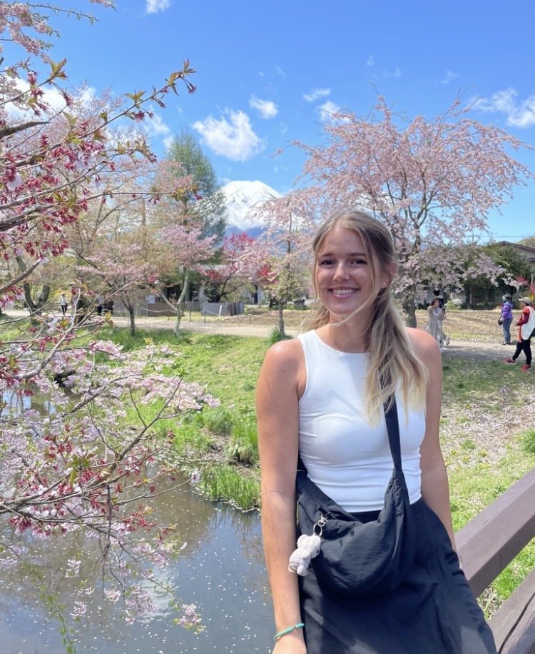 girl in front of cherry blossoms and snow topped mountain